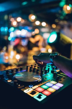 DJ, gece kulübünde canlı set ve pikabın konsolunda karışık müzik çalar. Disk Şakacı Eller kulüp partisinde ses karıştırıcı istasyonunda. Müzik çalmak ve parti yapmak için DJ karıştırıcı denetleyici paneli.