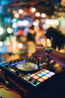 DJ, gece kulübünde canlı set ve pikabın konsolunda karışık müzik çalar. Disk Şakacı Eller kulüp partisinde ses karıştırıcı istasyonunda. Müzik çalmak ve parti yapmak için DJ karıştırıcı denetleyici paneli.