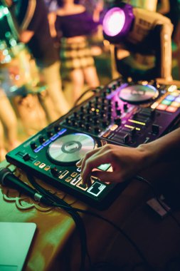 DJ, gece kulübünde canlı set ve pikabın konsolunda karışık müzik çalar. Disk Şakacı Eller kulüp partisinde ses karıştırıcı istasyonunda. Müzik çalmak ve parti yapmak için DJ karıştırıcı denetleyici paneli.