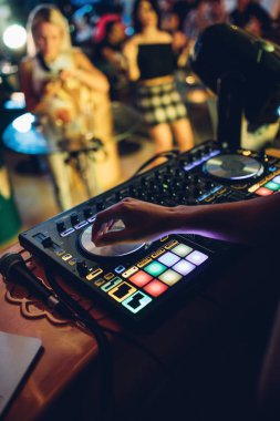 DJ, gece kulübünde canlı set ve pikabın konsolunda karışık müzik çalar. Disk Şakacı Eller kulüp partisinde ses karıştırıcı istasyonunda. Müzik çalmak ve parti yapmak için DJ karıştırıcı denetleyici paneli.