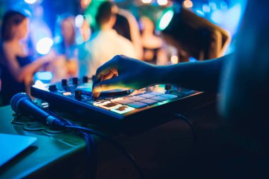 DJ, gece kulübünde canlı set ve pikabın konsolunda karışık müzik çalar. Disk Şakacı Eller kulüp partisinde ses karıştırıcı istasyonunda. Müzik çalmak ve parti yapmak için DJ karıştırıcı denetleyici paneli.