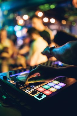 DJ, gece kulübünde canlı set ve pikabın konsolunda karışık müzik çalar. Disk Şakacı Eller kulüp partisinde ses karıştırıcı istasyonunda. Müzik çalmak ve parti yapmak için DJ karıştırıcı denetleyici paneli.