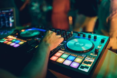 DJ, gece kulübünde canlı set ve pikabın konsolunda karışık müzik çalar. Disk Şakacı Eller kulüp partisinde ses karıştırıcı istasyonunda. Müzik çalmak ve parti yapmak için DJ karıştırıcı denetleyici paneli.