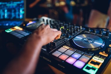 DJ, gece kulübünde canlı set ve pikabın konsolunda karışık müzik çalar. Disk Şakacı Eller kulüp partisinde ses karıştırıcı istasyonunda. Müzik çalmak ve parti yapmak için DJ karıştırıcı denetleyici paneli.