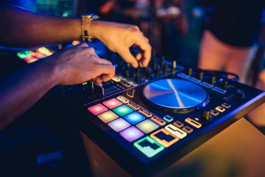 DJ, gece kulübünde canlı set ve pikabın konsolunda karışık müzik çalar. Disk Şakacı Eller kulüp partisinde ses karıştırıcı istasyonunda. Müzik çalmak ve parti yapmak için DJ karıştırıcı denetleyici paneli.