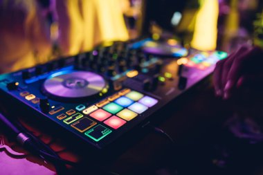 DJ, gece kulübünde canlı set ve pikabın konsolunda karışık müzik çalar. Disk Şakacı Eller kulüp partisinde ses karıştırıcı istasyonunda. Müzik çalmak ve parti yapmak için DJ karıştırıcı denetleyici paneli.