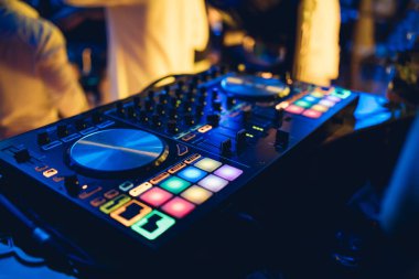 DJ, gece kulübünde canlı set ve pikabın konsolunda karışık müzik çalar. Disk Şakacı Eller kulüp partisinde ses karıştırıcı istasyonunda. Müzik çalmak ve parti yapmak için DJ karıştırıcı denetleyici paneli.