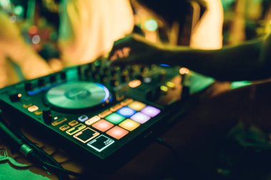 DJ, gece kulübünde canlı set ve pikabın konsolunda karışık müzik çalar. Disk Şakacı Eller kulüp partisinde ses karıştırıcı istasyonunda. Müzik çalmak ve parti yapmak için DJ karıştırıcı denetleyici paneli.