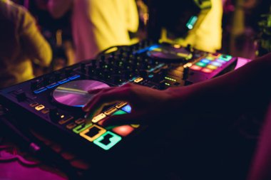 DJ, gece kulübünde canlı set ve pikabın konsolunda karışık müzik çalar. Disk Şakacı Eller kulüp partisinde ses karıştırıcı istasyonunda. Müzik çalmak ve parti yapmak için DJ karıştırıcı denetleyici paneli.