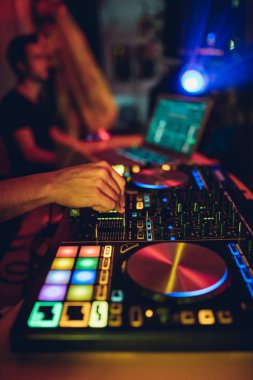 DJ, gece kulübünde canlı set ve pikabın konsolunda karışık müzik çalar. Disk Şakacı Eller kulüp partisinde ses karıştırıcı istasyonunda. Müzik çalmak ve parti yapmak için DJ karıştırıcı denetleyici paneli.