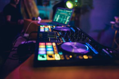 DJ, gece kulübünde canlı set ve pikabın konsolunda karışık müzik çalar. Disk Şakacı Eller kulüp partisinde ses karıştırıcı istasyonunda. Müzik çalmak ve parti yapmak için DJ karıştırıcı denetleyici paneli.