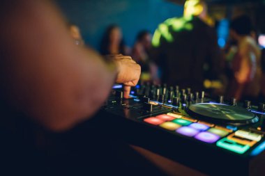 DJ, gece kulübünde canlı set ve pikabın konsolunda karışık müzik çalar. Disk Şakacı Eller kulüp partisinde ses karıştırıcı istasyonunda. Müzik çalmak ve parti yapmak için DJ karıştırıcı denetleyici paneli.