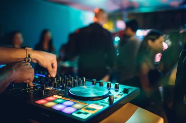 DJ, gece kulübünde canlı set ve pikabın konsolunda karışık müzik çalar. Disk Şakacı Eller kulüp partisinde ses karıştırıcı istasyonunda. Müzik çalmak ve parti yapmak için DJ karıştırıcı denetleyici paneli.