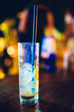 Masada kokteyl bardağı var. Gecenin sonunda neredeyse boş kokteyl bardağı bitmek üzereydi. Gece hayatı veya gece kulübü arka plan konsept görüntüsü.