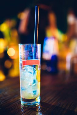 Masada kokteyl bardağı var. Gecenin sonunda neredeyse boş kokteyl bardağı bitmek üzereydi. Gece hayatı veya gece kulübü arka plan konsept görüntüsü.