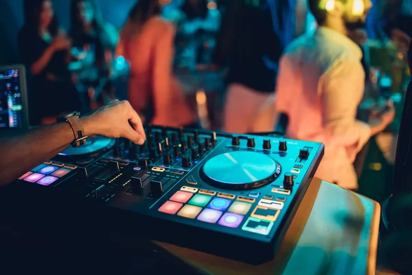 DJ, gece kulübünde canlı set ve pikabın konsolunda karışık müzik çalar. Disk Şakacı Eller kulüp partisinde ses karıştırıcı istasyonunda. Müzik çalmak ve parti yapmak için DJ karıştırıcı denetleyici paneli.