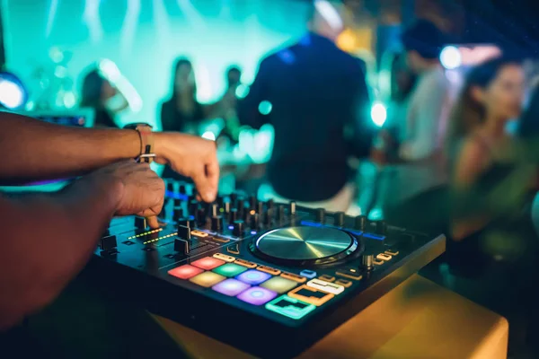 DJ, gece kulübünde canlı set ve pikabın konsolunda karışık müzik çalar. Disk Şakacı Eller kulüp partisinde ses karıştırıcı istasyonunda. Müzik çalmak ve parti yapmak için DJ karıştırıcı denetleyici paneli.