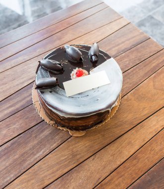 Üzerinde boş isim doğum günü kartı olan doğum günü pastası, Çikolatalı pasta.