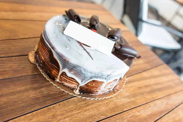 Üzerinde boş isim doğum günü kartı olan doğum günü pastası, Çikolatalı pasta.