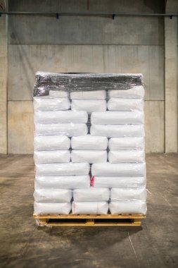 Modern fabrikada büyük depoda satır veya beyaz çuval torba yığınları. Fabrika veya depoda paketleme