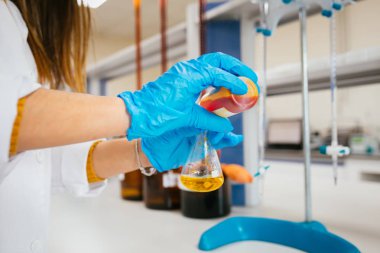Koruyucu eldivenkadın veya kadın elleri elinde test tüpü tutun kimya deney testi ve modern kimya laboratuvarında araştırma üretir. 