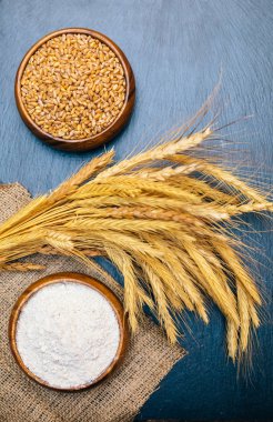 Fırında taze çavdar, somun veya tam tahıllı kahverengi ekmek, buğday kulağı veya başak ve un ahşap tahta masada. Fırın konsept görüntüsü.