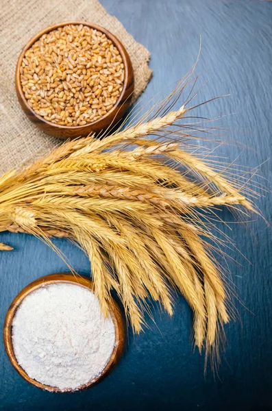 Fırında taze çavdar, somun veya tam tahıllı kahverengi ekmek, buğday kulağı veya başak ve un ahşap tahta masada. Fırın konsept görüntüsü.