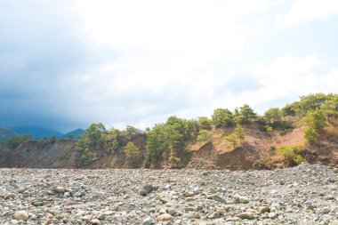 Türkiye 'nin Bodrum plajında Akdeniz ya da Ege kıyıları, kıyı ya da körfez kıyıları kaya ve dalgalarla kaplı. Mavi deniz, okyanus ve ağaçlarla dolu yaz günü manzarası. Türkiye 'de tatil ve tatil.