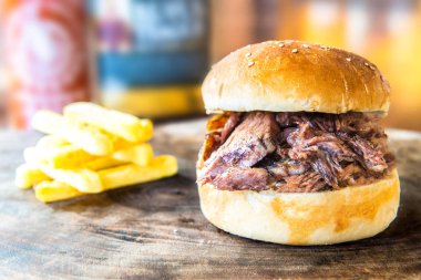 Hamburger, hamburger ve patates kızartması. Yakın plan lezzetli hamburger ya da hamburger. Bu hamburgerle patates kızartması kırsal ahşap masada. Fast food konsept görüntüsü.