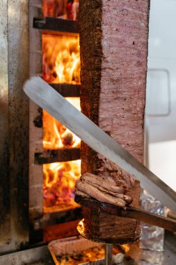 Geleneksel Türk Donör Kebap eti. Şef bıçak donörü, shawarma ya da jiroskopla kesiyor. Türk, Yunan ya da Ortadoğu tarzı kebap yapan kebapçılar ızgaranın önüne tükürüyor.