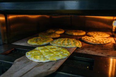 Geleneksel Türk Ramazan yemeği Pita ya da yumurta ve susamlı pide ekmeği fırında ya da sobada odun kürek üzerinde. Fırın ya da fırın konsepti resmi.