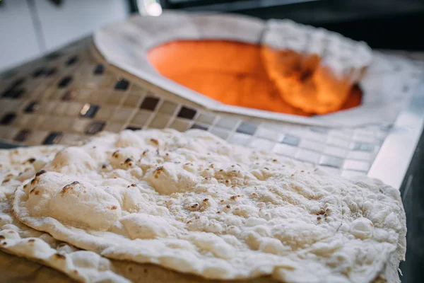 伝統的なトルコのラマダーンフードのピタ パイド ラバッシュ またはユフカパンを火で焼く石のオーブンで焼く タンディールまたはタンドア とも呼ばれる — ストック写真