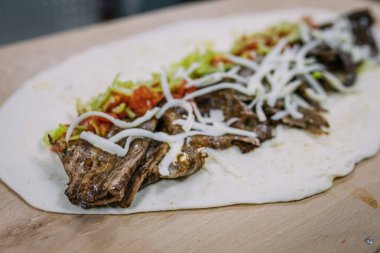 Geleneksel Türk Donör Kebabı İskender, shawarma veya gyros olarak da bilinir. Türk tarzı kebapçı Türk Restoranı 'nda ahşap masa arkasında kebap yapıyor