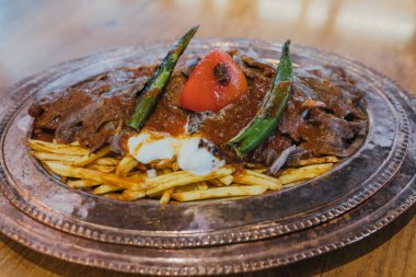 Geleneksel Türk Donör Kebabı İskender olarak da bilinir. Türk tarzı kebap yapan kebap ahşap masa arkasında.