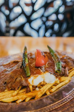 Geleneksel Türk Donör Kebabı İskender olarak da bilinir. Türk tarzı kebap yapan kebap ahşap masa arkasında.