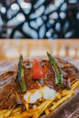 Geleneksel Türk Donör Kebabı İskender olarak da bilinir. Türk tarzı kebap yapan kebap ahşap masa arkasında.