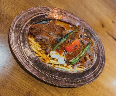 Geleneksel Türk Donör Kebabı İskender olarak da bilinir. Türk tarzı kebap yapan kebap ahşap masa arkasında.