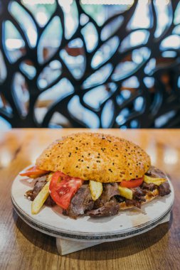 Geleneksel Türk Donör Kebabı İskender, shawarma veya gyros olarak da bilinir. Türk tarzı kebapçı Türk Restoranı 'nda ahşap masa arkasında kebap yapıyor