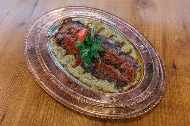 Geleneksel Türk Donör Kebabı İskender olarak da bilinir. Türk tarzı kebap yapan kebap ahşap masa arkasında.
