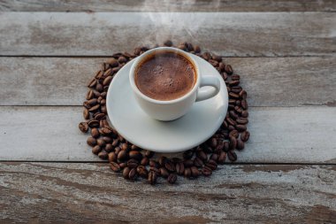 Beyaz ahşap masada kahve çekirdekleri dökülmüş Türk ya da Yunan kahvesi. Bu Yunan ya da Türk mutfağından geleneksel lezzetli Yunan ya da Türk kahvesi.