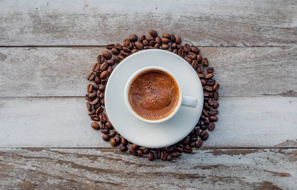 Turkish or Greek Hot Coffee on the white rustic wooden table with spilled coffee beans. This is traditional tasty refreshment greek or turkish coffee from greek or turkish cuisine culture