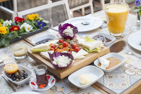 Turkish tea with breakfast on the table in front of sea background landscape at Summer season. Turkish or Greek Breakfast at seaside. Breakfast on the beach at hotel or resort by the sea in summer season. Holiday and vacation breakfast image.