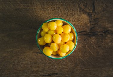 Sarı kiraz meyveleri. Sarı renkli kirazlar antika kumaş ve ahşap masa üzerindeki antika retro kasede.