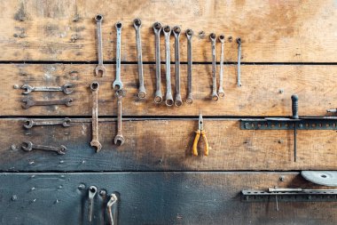 Atölye sahnesi. Atölyede duvarda asılı duran eski aletler. Eski moda garaj tarzı. Eski garajda asılı duran eski anahtarlar..