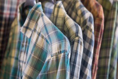 Bir grup renkli pamuklu gömlek. Çeşitli gömlek kumaş örnekleri. Tişört desenli arkaplan