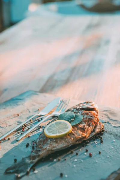 Grilled fish or Seafood on the table in Fish Restaurant. Beach Restaurant in Greece or Turkey. Aegean seaside, Greek or Turkish style fish restaurant in Bodrum, Santorini or Mykonos