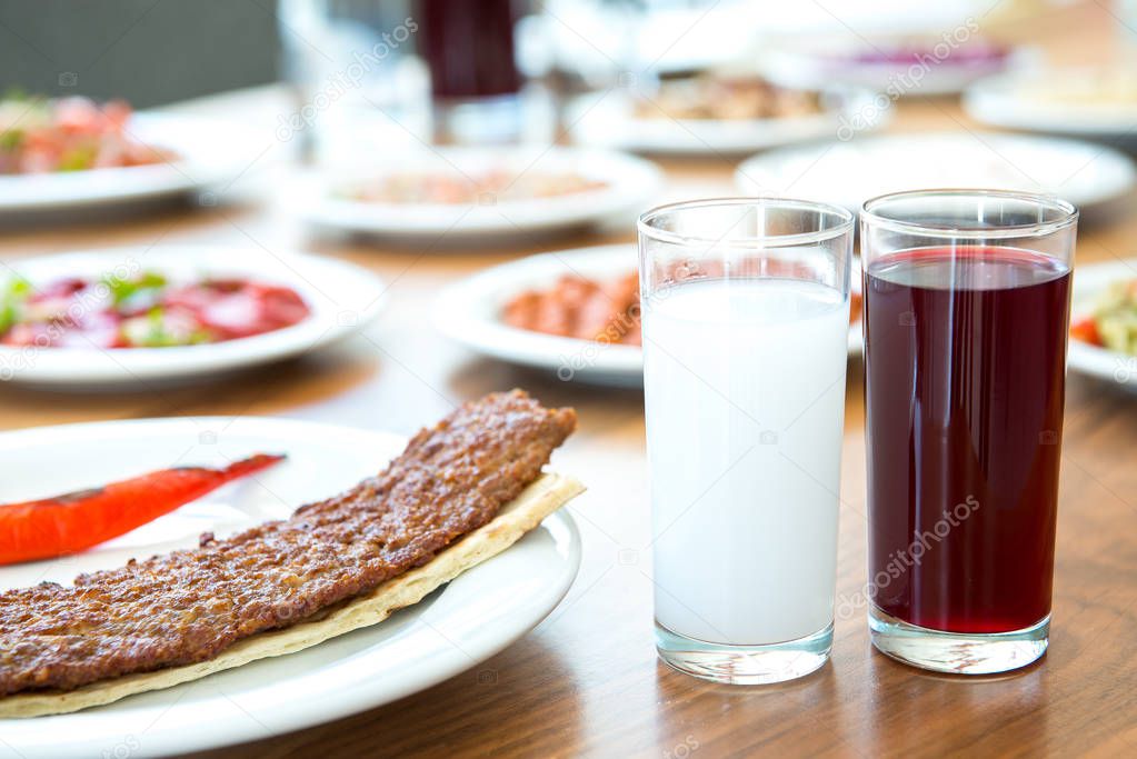 Traditional Turkish Drink Raki, Salgam (Turnip Juice) with Adana Kebap and appetizers. Selective Focus Turkish Dining Dinner Table.