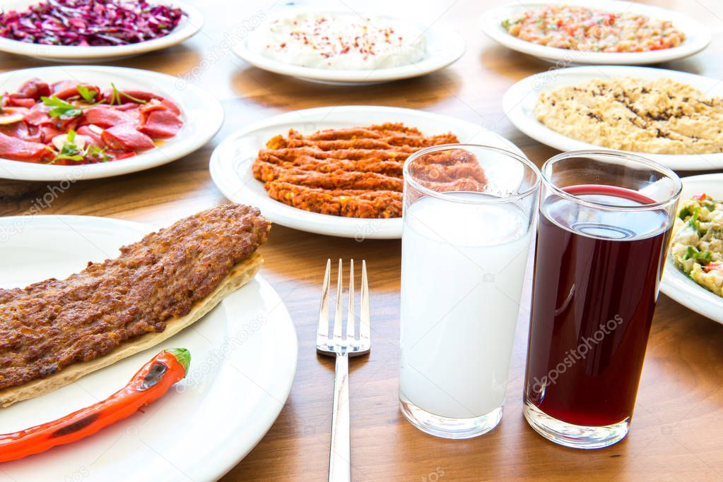 Traditional Turkish Drink Raki, Salgam (Turnip Juice) with Adana Kebap and appetizers. Selective Focus Turkish Dining Dinner Table.