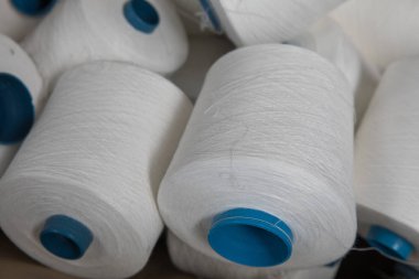 İplik ipliklerini, makaraları, bobin tüplerini kapatın. Tekstil endüstrisi kumaş konsepti arkaplan resmi.