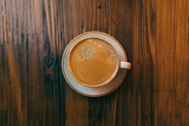 Kahve dükkanında, kafede ya da restoranda, ahşap masanın üzerinde bir fincan espresso..